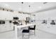 Modern kitchen featuring white cabinets, stainless steel appliances, an island with chairs, and stylish pendant lighting at 10249 Spring Lake Dr, Clermont, FL 34711
