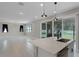 Beautiful kitchen with modern lighting, an island with a sink, and a view into the living space at 10249 Spring Lake Dr, Clermont, FL 34711