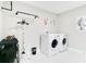 Bright laundry room features modern washer and dryer and a unique hanging rack at 10249 Spring Lake Dr, Clermont, FL 34711