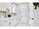Well-lit laundry room featuring white cabinets, sleek black hardware, and a functional countertop at 10249 Spring Lake Dr, Clermont, FL 34711