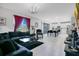 Spacious living room featuring a modern sofa, chandelier, large windows, and an open view of the kitchen at 10249 Spring Lake Dr, Clermont, FL 34711