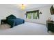 Bright primary bedroom featuring a comfortable bed, large windows, a chandelier, and neutral-toned walls at 10249 Spring Lake Dr, Clermont, FL 34711