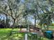 Community playground with a slide, climbing structure, swings and picnic tables under shady trees at 10249 Spring Lake Dr, Clermont, FL 34711