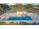 Inviting community pool surrounded by white picket fence, chairs, and tennis courts at 10249 Spring Lake Dr, Clermont, FL 34711