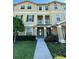Inviting three-story townhome with a well-maintained lawn and charming front walkway, complete with a small balcony at 10506 Green Ivy Lane, Orlando, FL 32832