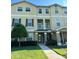 Inviting three-story townhome with a well-maintained lawn and charming front walkway, complete with a small balcony at 10506 Green Ivy Lane, Orlando, FL 32832
