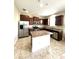 Spacious kitchen boasting stainless steel appliances, dark wood cabinetry, granite countertops, and a central island at 10506 Green Ivy Lane, Orlando, FL 32832