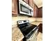 Close-up of the modern kitchen featuring granite countertops, wood cabinetry, and stainless steel appliances including a range at 10506 Green Ivy Lane, Orlando, FL 32832
