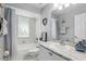 Bright bathroom features a shower and tub combo, white vanity, and a decorative mirror at 10664 Spring Buck Trl, Orlando, FL 32825