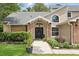 Close up of the home's entrance with a well-manicured lawn and mature trees at 10664 Spring Buck Trl, Orlando, FL 32825