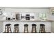 A kitchen bar with five barstools provides a view into the kitchen area featuring stainless steel appliances at 10664 Spring Buck Trl, Orlando, FL 32825