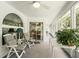 Enclosed sunroom with two chairs, a table and a large window providing a tranquil space to relax and enjoy views at 10664 Spring Buck Trl, Orlando, FL 32825