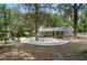 Backyard with circular patio, mature trees, lush landscaping, and charming brick home at 1090 Braddock Rd, Deltona, FL 32725