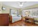 Bedroom with hardwood floors, a window view, and a ceiling fan above a cozy desk space at 1090 Braddock Rd, Deltona, FL 32725