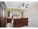 A cozy bedroom featuring a large bed, white closet doors, a ceiling fan, and a bright window at 1090 Braddock Rd, Deltona, FL 32725
