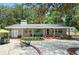 Charming single-story home features a brick facade, manicured front yard with mature trees, and a welcoming patio area at 1090 Braddock Rd, Deltona, FL 32725