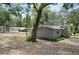 Charming gray brick home with a lush landscaped garden surrounded by tall trees at 1090 Braddock Rd, Deltona, FL 32725
