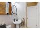 A well-lit powder room with a pedestal sink, decorative mirror, and white walls at 1090 Braddock Rd, Deltona, FL 32725