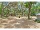 Large open yard with mature trees, Spanish moss, a covered structure and charming brick house at 1090 Braddock Rd, Deltona, FL 32725