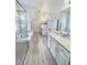 Bright bathroom features a soaking tub, glass shower, dual sinks, and white cabinets with a modern design at 1101 Rush Ct, Celebration, FL 34747