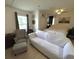 Bright bedroom features neutral colors, a large bed, seating area, and plenty of natural light from the window at 1101 Rush Ct, Celebration, FL 34747