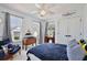 Bright bedroom featuring a ceiling fan, two windows with curtains, and nautical-themed decor at 1101 Rush Ct, Celebration, FL 34747