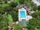 An aerial view of a large community pool with a pool house, trees, and a playground nearby at 1101 Rush Ct, Celebration, FL 34747