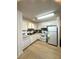 Functional kitchen with white appliances and cabinets, a practical layout, and durable wood-look flooring at 1101 Rush Ct, Celebration, FL 34747