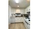 Well-maintained kitchen with white cabinetry, stainless steel sink, and updated wood-look flooring at 1101 Rush Ct, Celebration, FL 34747