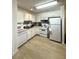 Bright kitchen featuring white cabinets, appliances, and wood-look floors at 1101 Rush Ct, Celebration, FL 34747