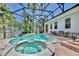 Relaxing screened-in pool and spa area with lush tropical landscaping, ample seating, and stylish brick pavers at 1101 Rush Ct, Celebration, FL 34747