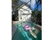 Sparkling screened-in pool with hot tub and backyard views featuring colorful floaties at 1101 Rush Ct, Celebration, FL 34747