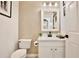 Stylish powder room featuring a textured wall, white vanity, and modern fixtures at 1101 Rush Ct, Celebration, FL 34747