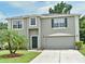 Inviting two-story home showcasing a well-manicured lawn and attached two-car garage at 115 Bristol Forest Trl, Sanford, FL 32771