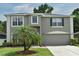 Inviting two-story home showcasing a well-manicured lawn and attached two-car garage at 115 Bristol Forest Trl, Sanford, FL 32771