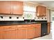 Kitchen with black appliances, granite countertops, wood cabinets, and window at 115 Bristol Forest Trl, Sanford, FL 32771