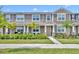 Charming two-story townhome featuring a well-manicured lawn and inviting front porch, perfect for relaxing outdoors at 11574 Buoy Point Pl, Orlando, FL 32832