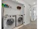 Well-organized laundry room equipped with modern washer and dryer, and storage shelving above at 11574 Buoy Point Pl, Orlando, FL 32832