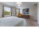 Sun-filled bedroom features two windows, modern furnishings, and artwork at 11631 Mystery Ln, Orlando, FL 32832