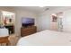 The bedroom features a television atop dresser, a queen-sized bed, and an attached bathroom at 11631 Mystery Ln, Orlando, FL 32832