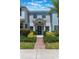 Inviting townhome featuring a brick walkway, manicured landscaping, and a welcoming front door at 11631 Mystery Ln, Orlando, FL 32832
