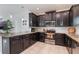 Stylish kitchen featuring dark cabinetry and stainless-steel appliances, perfect for culinary enthusiasts at 11631 Mystery Ln, Orlando, FL 32832
