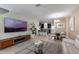 Open-concept living room featuring a large television, kitchen and breakfast bar at 11631 Mystery Ln, Orlando, FL 32832