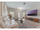 Inviting living room features a plush white sofa, glass coffee table and large screen TV at 11631 Mystery Ln, Orlando, FL 32832