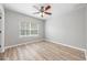 A bright bedroom with vinyl floors, a ceiling fan, and ample natural light from the window at 124 Mcleods Way, Winter Springs, FL 32708