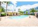 Community pool with crystal clear water, tropical palms, and ample lounge area on a sunny day at 124 Mcleods Way, Winter Springs, FL 32708