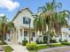 Charming two-story home with a porch, manicured landscaping, and lush palm trees at 124 Mcleods Way, Winter Springs, FL 32708