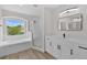 Bathroom with a soaking tub, shower, modern vanity, and matte black faucet at 12917 Grovehurst Ave, Winter Garden, FL 34787