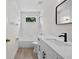The bathroom has a tub shower, toilet, and modern white vanity with black hardware at 12917 Grovehurst Ave, Winter Garden, FL 34787