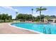 Inviting community pool with lounge chairs, surrounded by lush landscaping and palm trees at 12917 Grovehurst Ave, Winter Garden, FL 34787